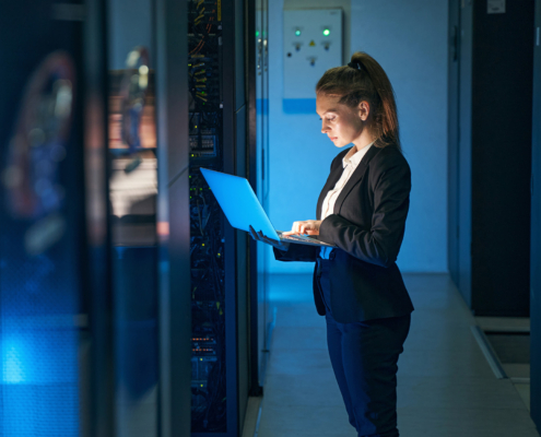 Female engineer working in server room at modern data center